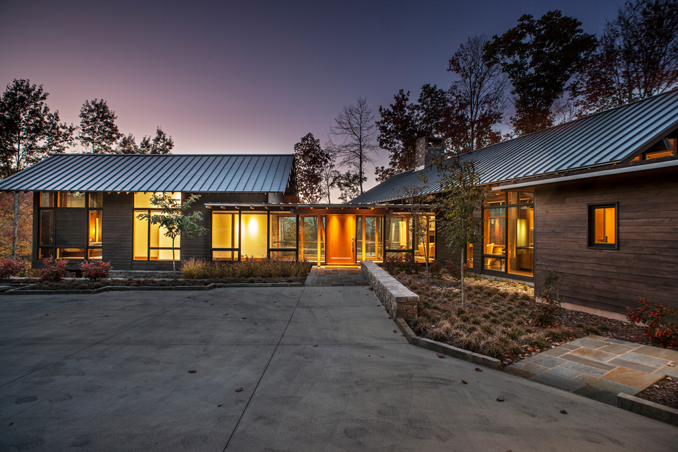 Стильный дизайн: большой, двухэтажный, деревянный, коричневый частный загородный дом в стиле модернизм с двускатной крышей и металлической крышей - последний тренд