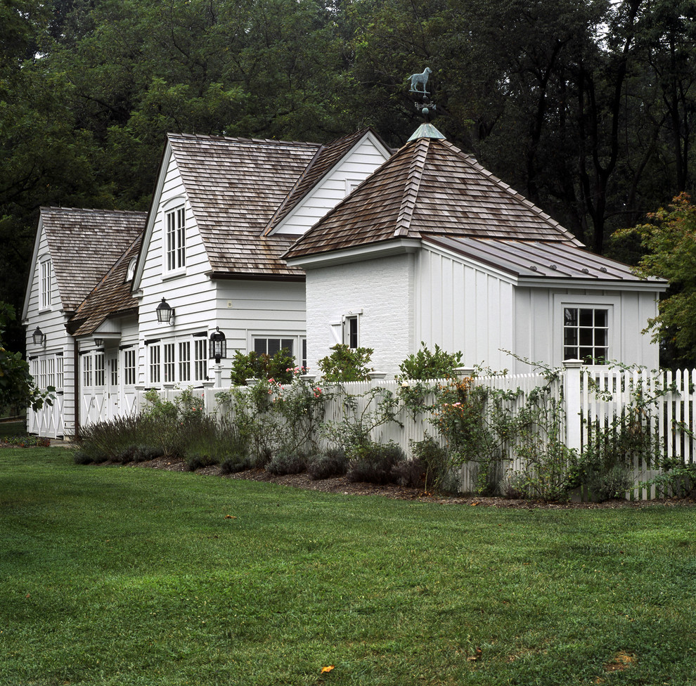 Immagine della facciata di una casa bianca shabby-chic style a due piani con rivestimento in legno e copertura mista