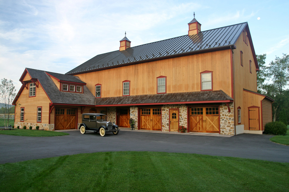 Esempio della villa marrone country a due piani di medie dimensioni con rivestimento in legno, tetto a padiglione e copertura in metallo o lamiera