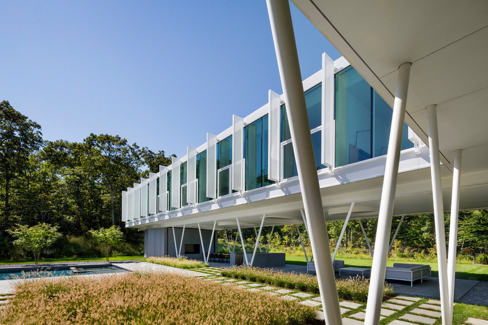 Diseño de fachada de casa blanca moderna grande de dos plantas con revestimiento de vidrio, tejado plano y techo verde