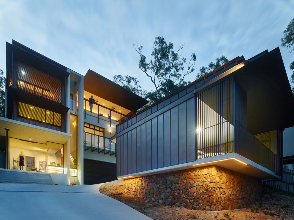 Стильный дизайн: большой, трехэтажный, коричневый дом в современном стиле с облицовкой из металла - последний тренд