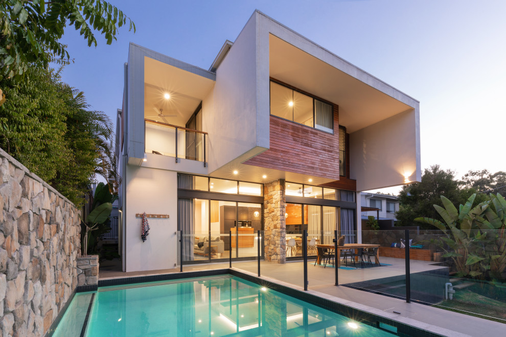 This is an example of a medium sized contemporary two floor detached house in Brisbane with mixed cladding and a flat roof.