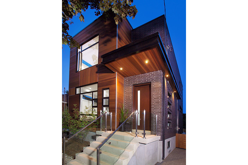 Idée de décoration pour une façade de maison noire minimaliste en brique de taille moyenne et à un étage avec un toit plat.