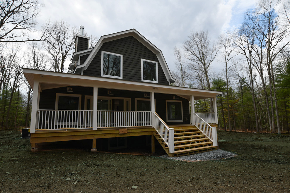 Cette photo montre une grande façade de maison grise nature en bois à un étage avec un toit de Gambrel et un toit en shingle.