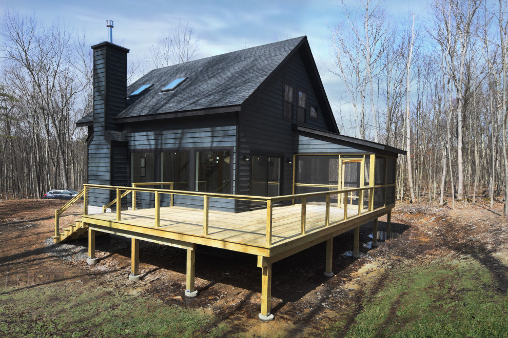 Foto della villa nera country a due piani di medie dimensioni con rivestimento in legno, tetto a capanna e copertura in metallo o lamiera