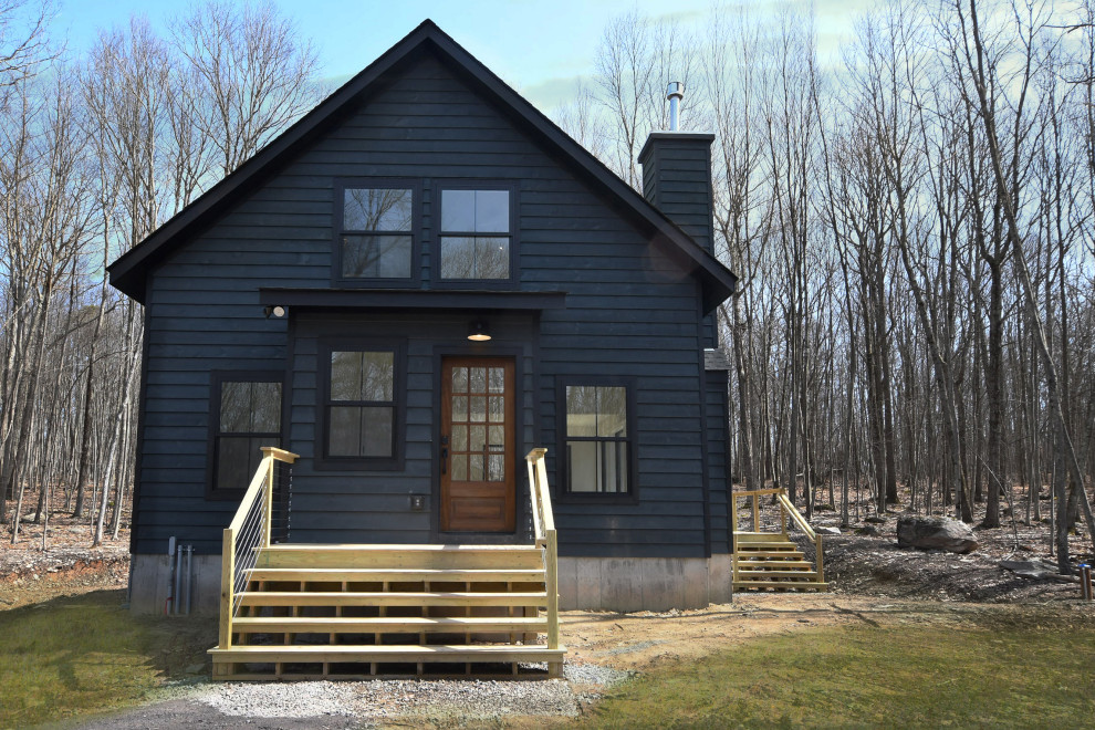 This is an example of a medium sized and black country two floor detached house in New York with wood cladding, a pitched roof and a metal roof.