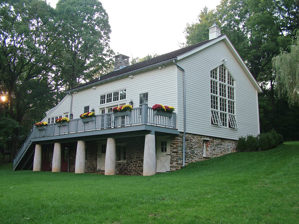 Diseño de fachada beige de estilo de casa de campo de tres plantas con revestimiento de madera