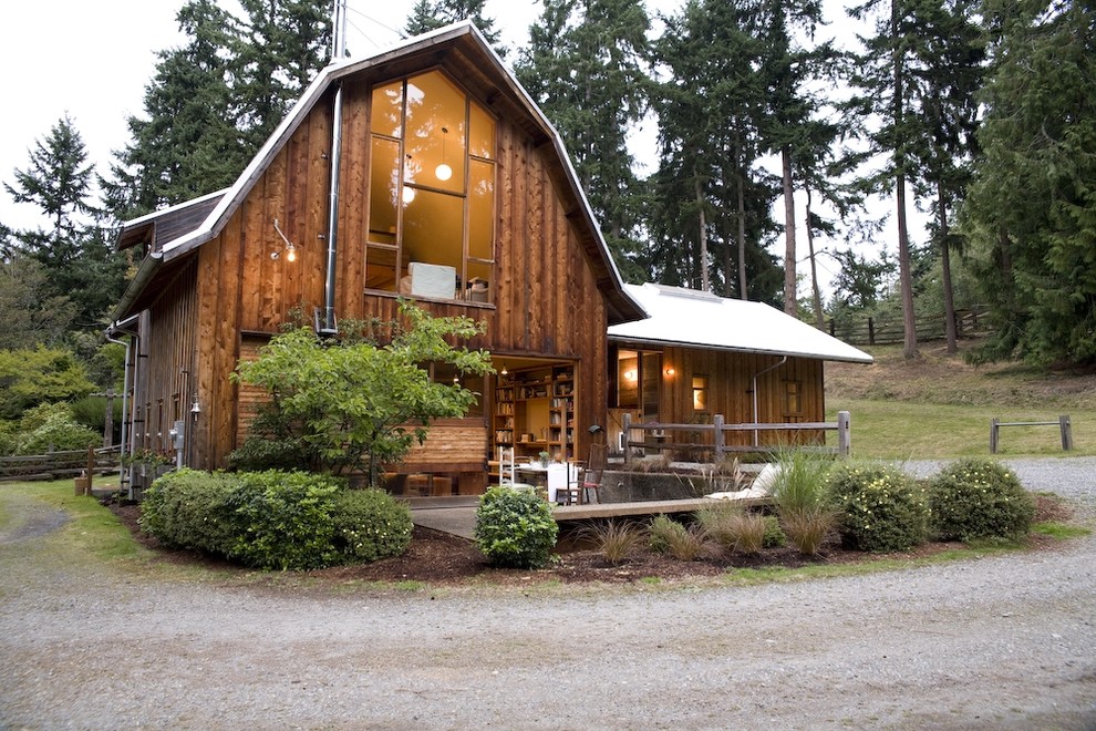 Medium sized and brown rustic two floor detached house in Seattle with wood cladding, a mansard roof and a metal roof.