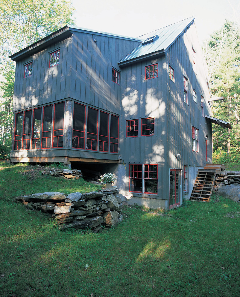 Immagine della facciata di una casa grigia country a due piani con rivestimento in legno