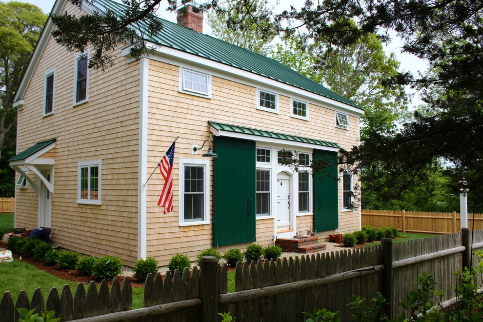 Mittelgroßes, Zweistöckiges Stilmix Einfamilienhaus mit Vinylfassade, beiger Fassadenfarbe, Satteldach und Blechdach in Boston