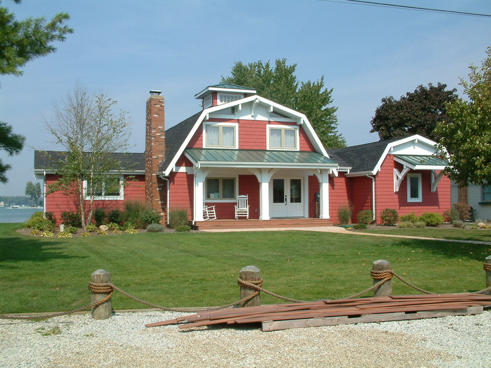Immagine della facciata di una casa rossa country a due piani con rivestimento in vinile