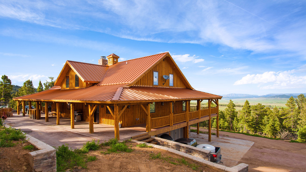Photo of a large rustic house exterior in Other with three floors and wood cladding.