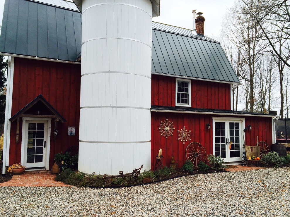 Ejemplo de fachada roja de estilo de casa de campo de dos plantas con revestimiento de madera