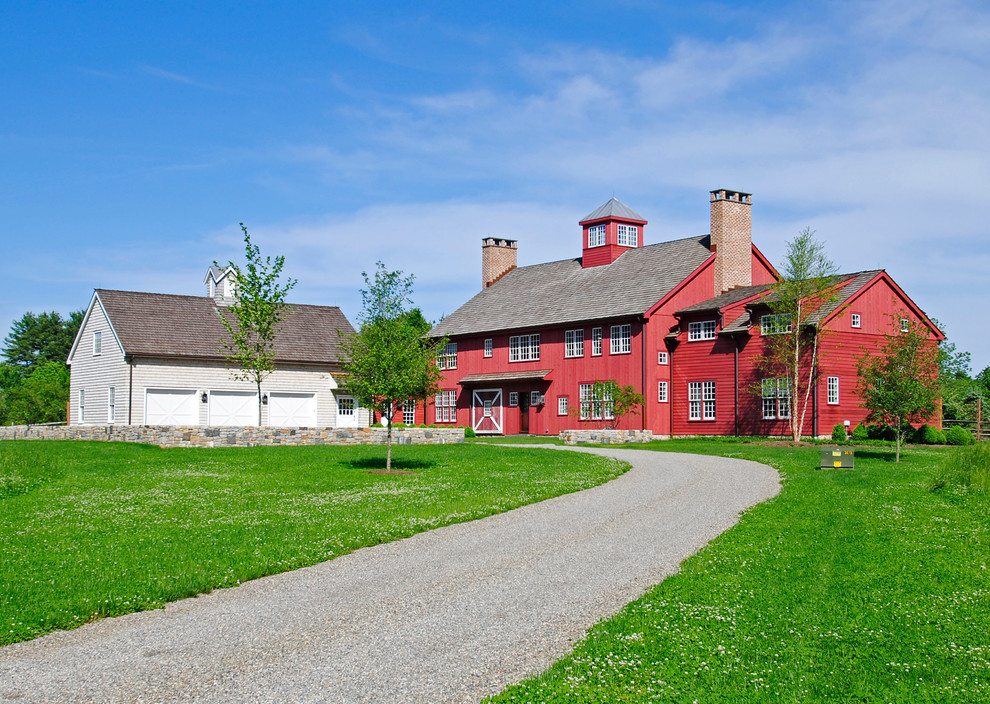 Esempio della facciata di una casa grande rossa country a due piani con rivestimento in legno e tetto a capanna