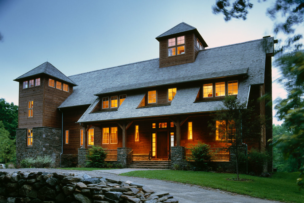 Ejemplo de fachada marrón de estilo de casa de campo grande de tres plantas con revestimiento de madera