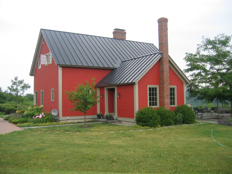 Example of a farmhouse red two-story wood exterior home design in Other
