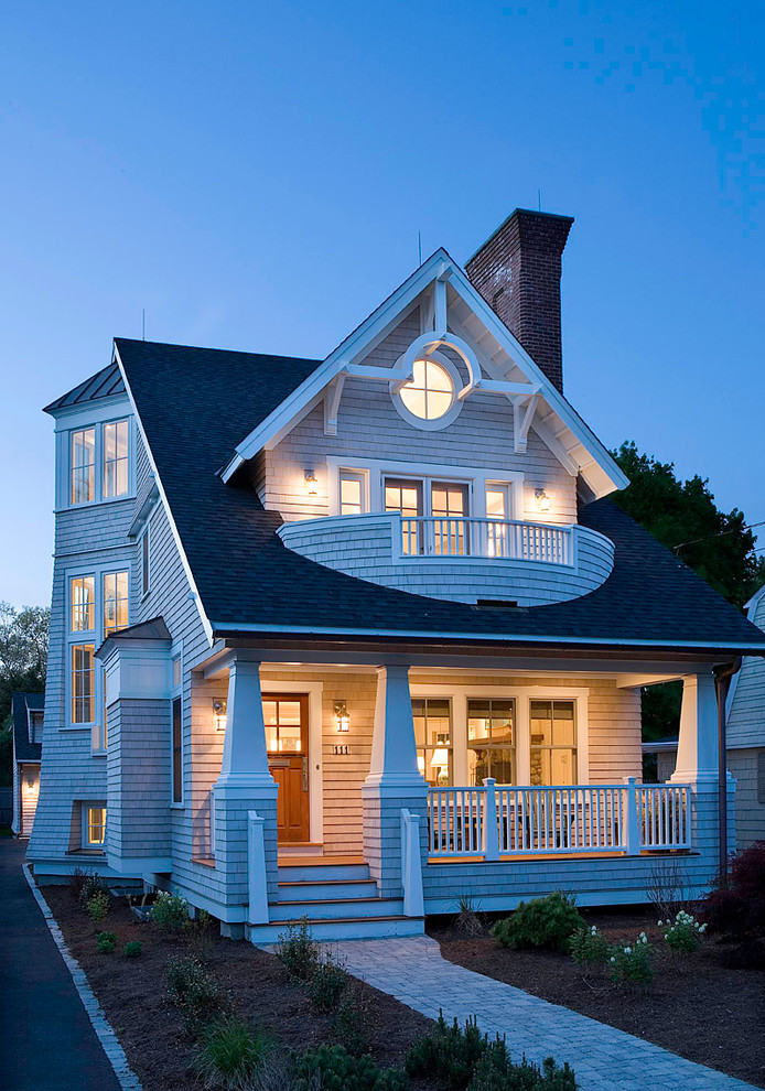 На фото: большой, трехэтажный, деревянный, серый дом в морском стиле с двускатной крышей