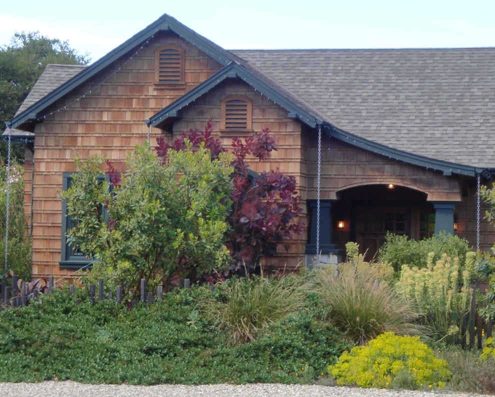 Imagen de fachada marrón rural grande de una planta con revestimientos combinados y tejado a dos aguas
