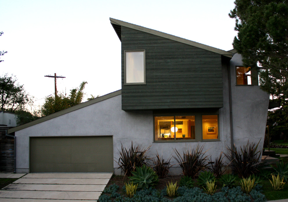 Cette image montre une façade de maison verte minimaliste en stuc de taille moyenne et à un étage.