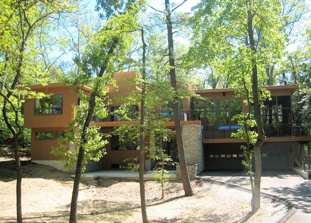 Aménagement d'une grande façade de maison marron contemporaine en bois à un étage avec un toit plat.