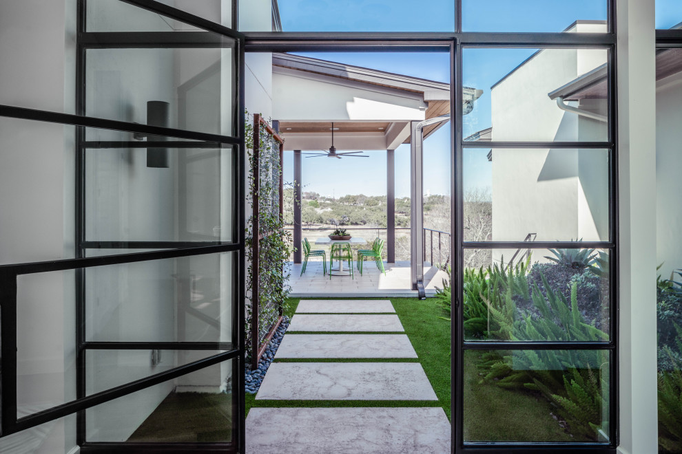 This is an example of an expansive and white modern detached house in Austin with three floors.