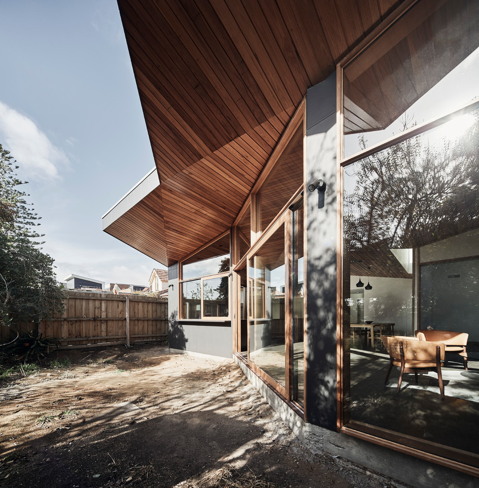 Diseño de fachada de casa gris contemporánea de tamaño medio de una planta con revestimiento de aglomerado de cemento, tejado plano y tejado de metal