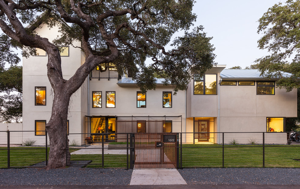 Großes, Zweistöckiges Modernes Haus mit Putzfassade, weißer Fassadenfarbe und Satteldach in Austin