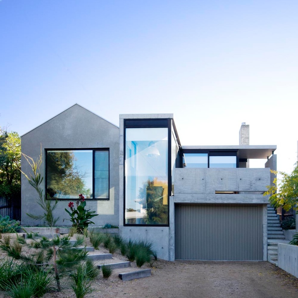 На фото: двухэтажный, серый частный загородный дом в современном стиле с облицовкой из бетона