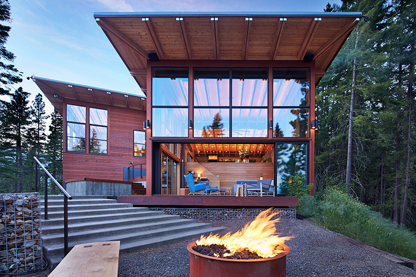 Стильный дизайн: большой, трехэтажный, деревянный, коричневый дом в стиле модернизм с плоской крышей для охотников - последний тренд