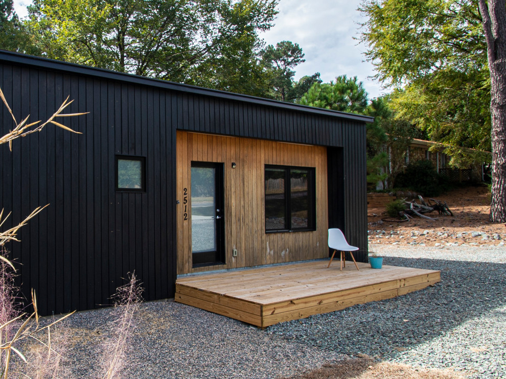 Réalisation d'une petite façade de maison noire nordique en bois de plain-pied avec un toit à deux pans et un toit en shingle.