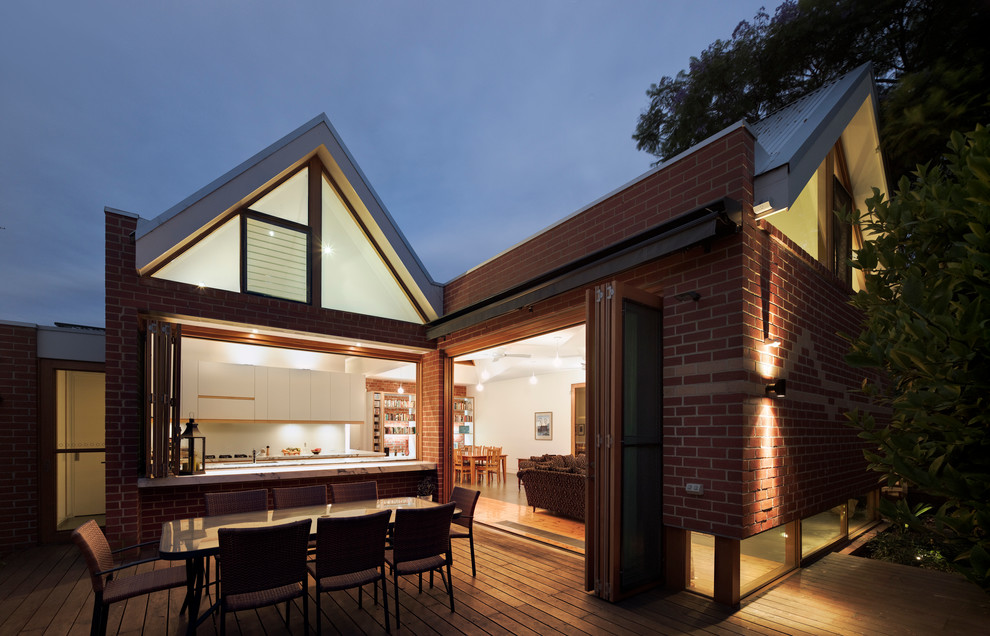 Cette image montre une façade de maison rouge design en brique de taille moyenne et de plain-pied avec un toit à deux pans.