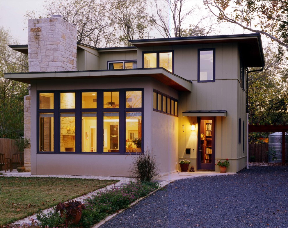 Esempio della facciata di una casa bifamiliare beige contemporanea a due piani di medie dimensioni con rivestimento in stucco e tetto piano