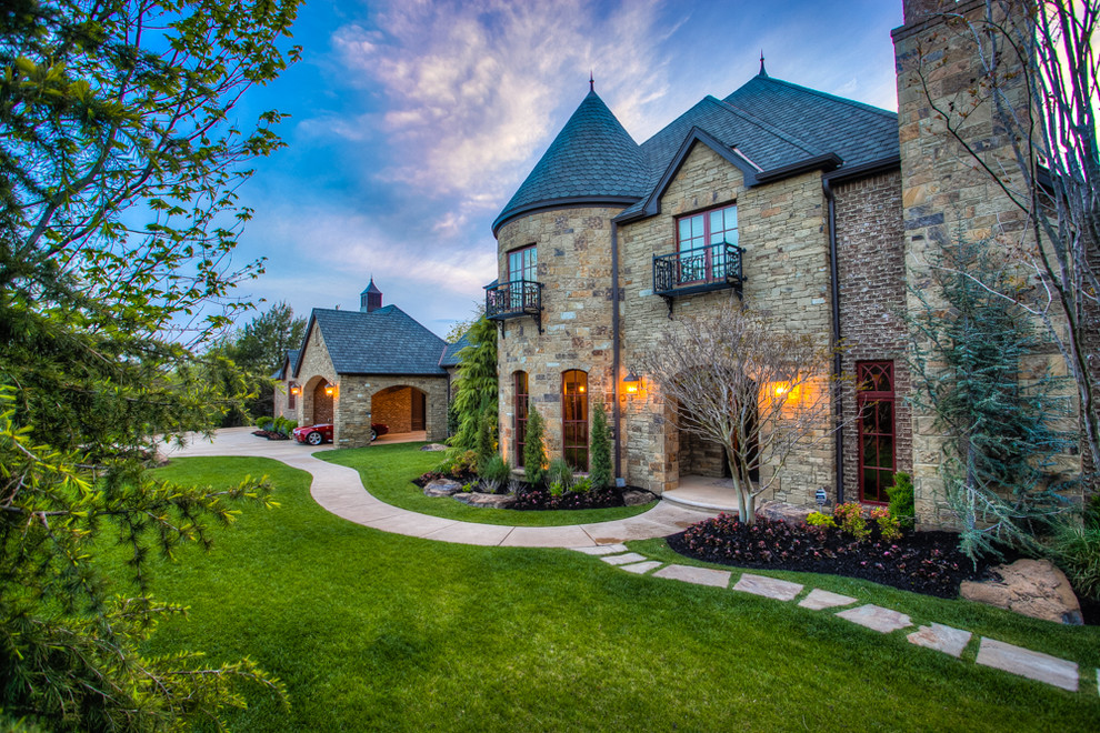 Example of a large french country beige two-story stone gable roof design in Oklahoma City