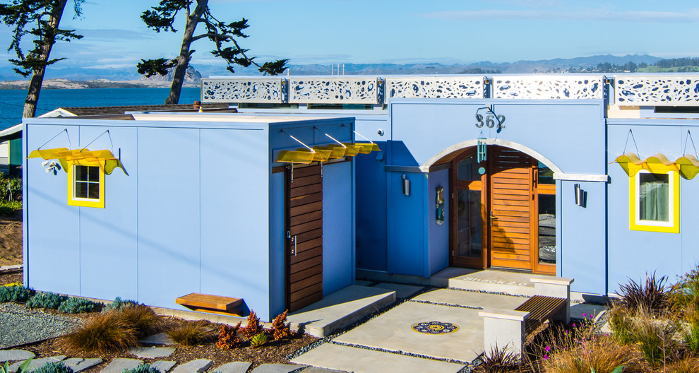 Foto della villa piccola blu contemporanea a un piano con rivestimento in legno, tetto piano e copertura in tegole