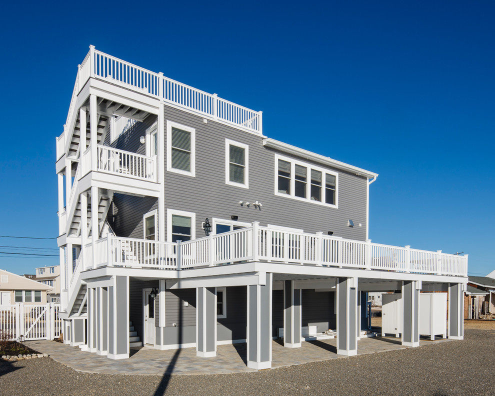 Design ideas for a gey coastal two floor house exterior in New York with vinyl cladding.