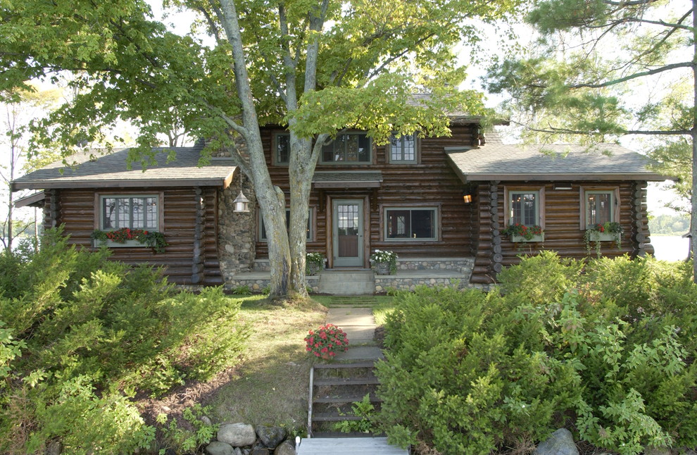 Aménagement d'une façade de maison marron montagne en bois de plain-pied avec un toit à deux pans.