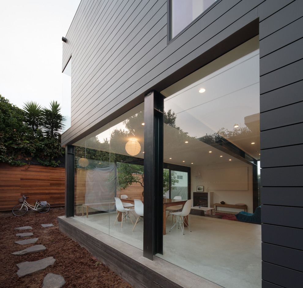 Foto de fachada gris contemporánea de tamaño medio de dos plantas con revestimiento de aglomerado de cemento y tejado plano