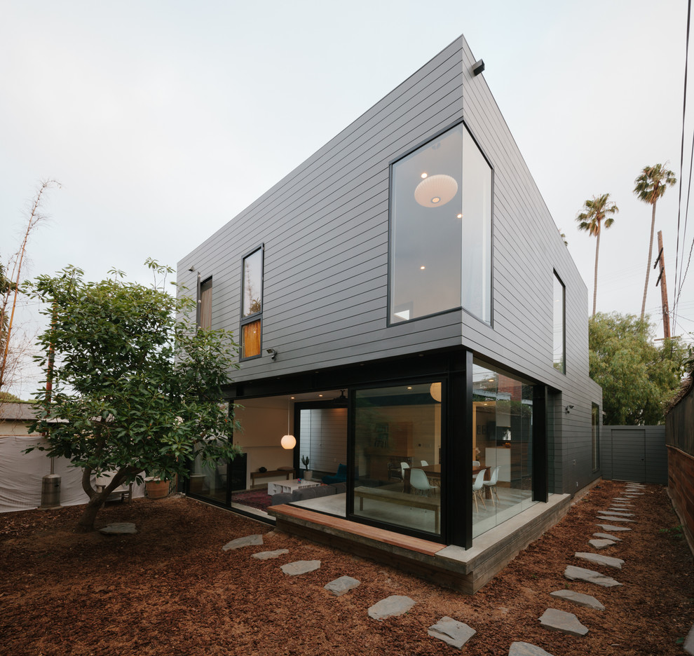 Ispirazione per la facciata di una casa grigia contemporanea a due piani di medie dimensioni con rivestimento con lastre in cemento e tetto piano