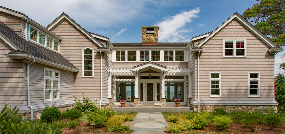 Esempio della villa grande beige stile marinaro a due piani con rivestimento in legno, copertura a scandole e tetto a capanna