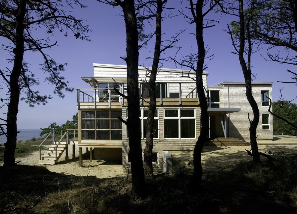 Aménagement d'une façade de maison bord de mer en bois de taille moyenne et à un étage.
