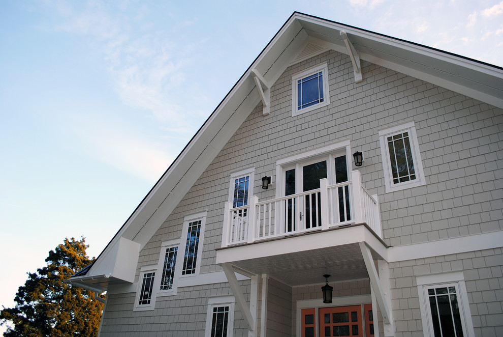 Example of a large beach style beige two-story wood house exterior design in Richmond with a clipped gable roof and a metal roof