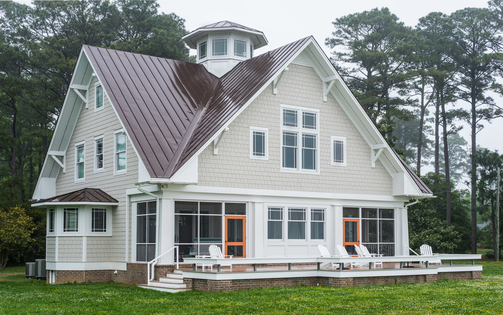 Immagine della villa grande beige stile marinaro a due piani con rivestimento in legno, falda a timpano e copertura in metallo o lamiera