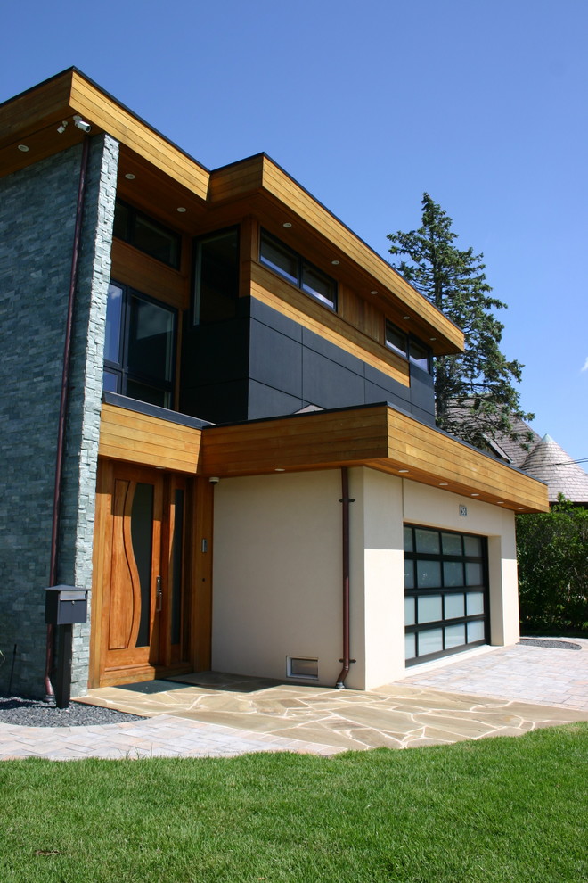 Esempio della villa multicolore moderna a due piani di medie dimensioni con rivestimenti misti e tetto piano
