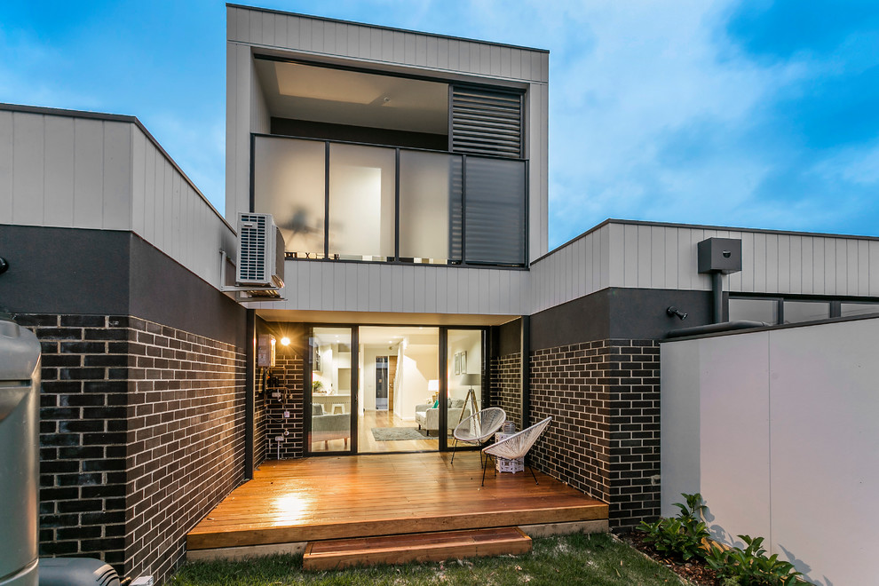 Kleines, Zweistöckiges Modernes Reihenhaus mit Mix-Fassade, brauner Fassadenfarbe, Flachdach und Blechdach in Melbourne
