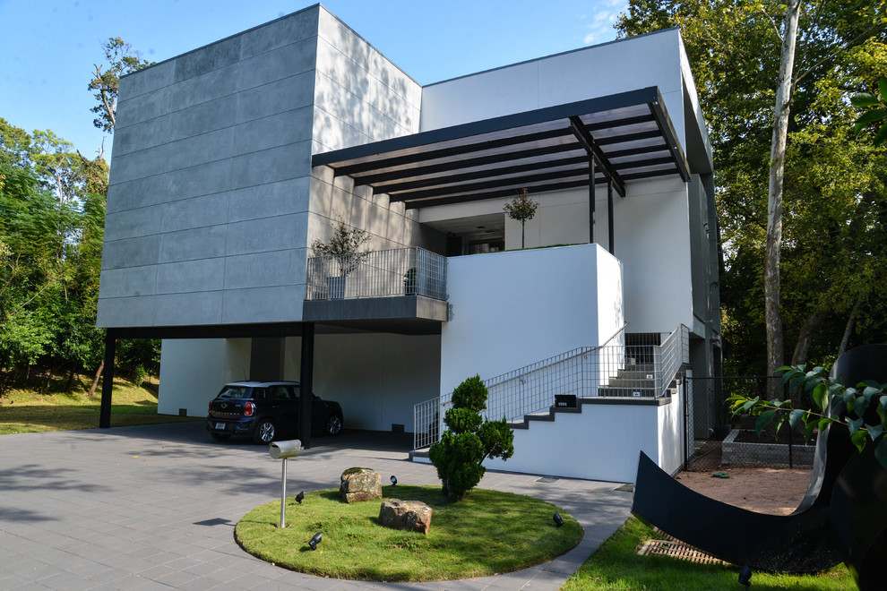 Modelo de fachada gris contemporánea grande de tres plantas con revestimiento de hormigón y tejado plano