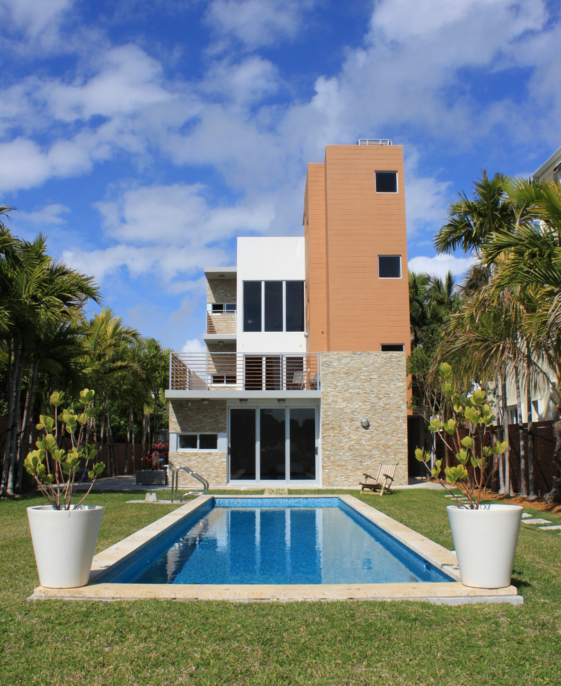 Kleines, Dreistöckiges Modernes Haus mit Mix-Fassade, weißer Fassadenfarbe und Flachdach in Miami