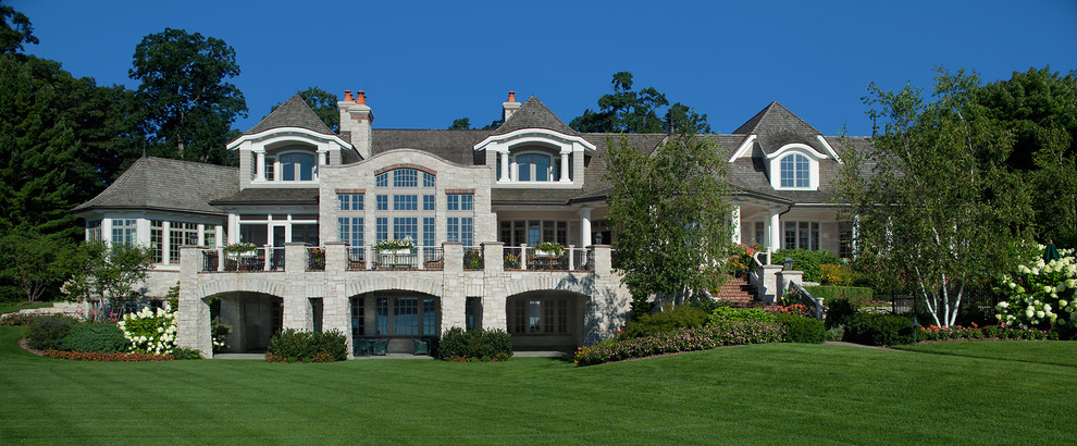 グランドラピッズにある巨大なトラディショナルスタイルのおしゃれな家の外観 (石材サイディング) の写真