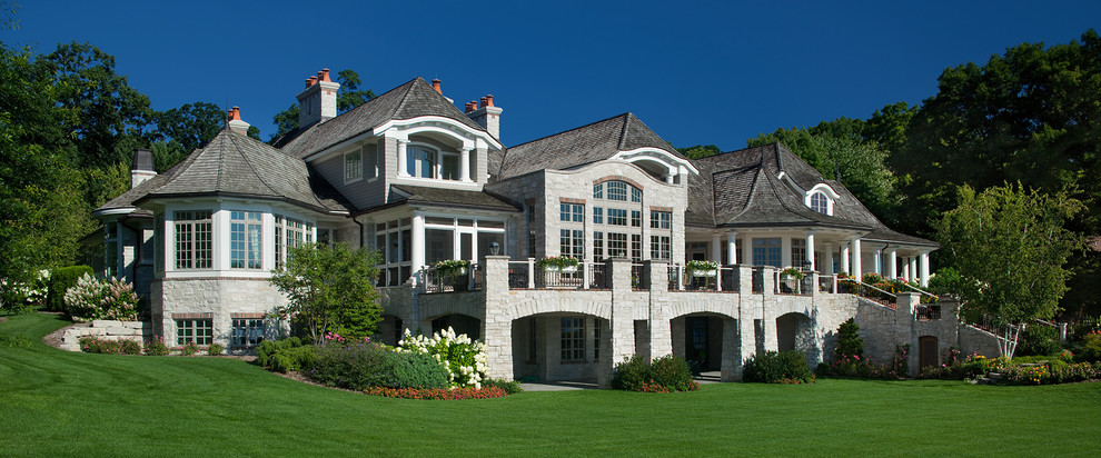 Inspiration for an expansive and gey traditional house exterior in Grand Rapids with three floors and stone cladding.
