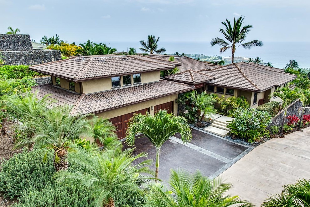 Huge tropical two-story stucco exterior home idea in Hawaii