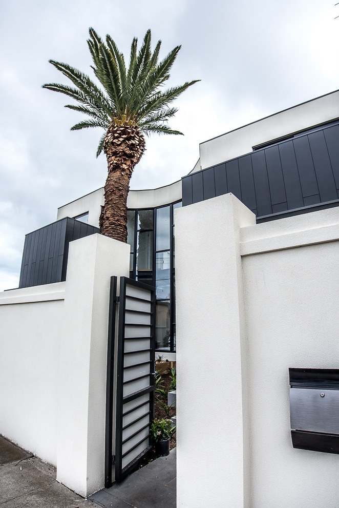 Foto della facciata di una casa bianca contemporanea a due piani di medie dimensioni con rivestimento in stucco e tetto piano